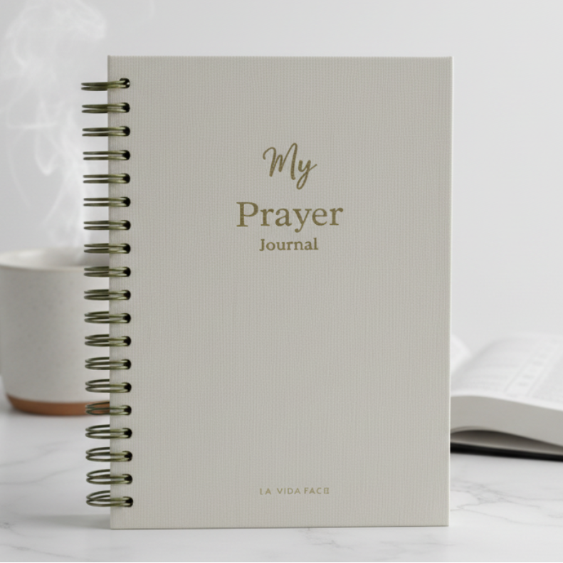 Open notebook with 'My Prayer Journal' on a marble surface next to a steaming mug.